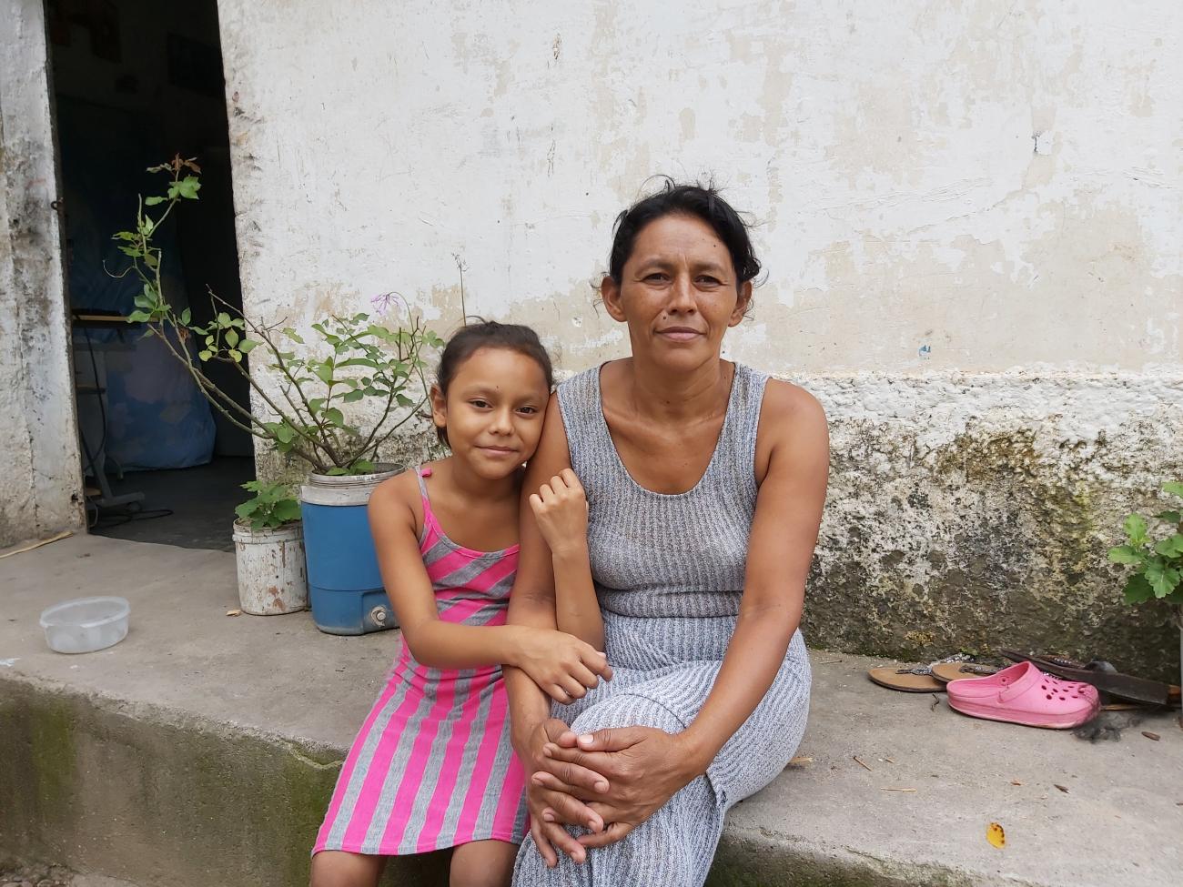 Beneficiaria Daysi Castro junto a su hija frente a su casa en Comayagua