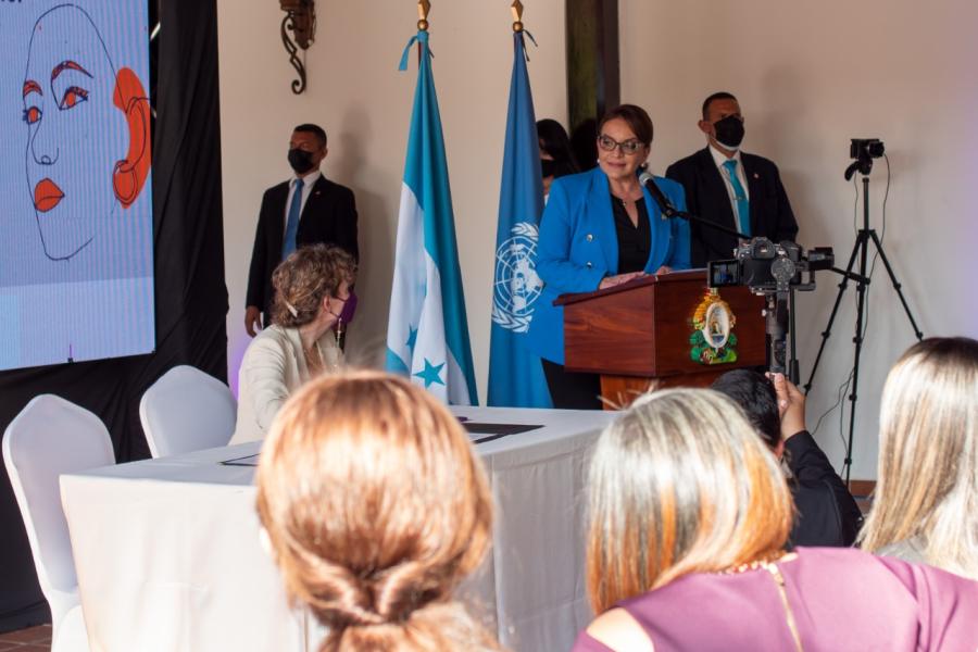 Xiomara Castro, Presidenta de Honduras frente a un podio dirigiendose a la audiencia en el evento de firma de compromiso contra violencia hacia mujeres