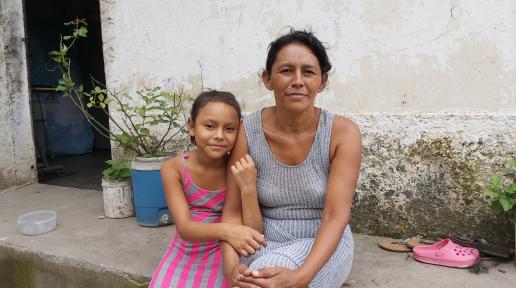 Beneficiaria Daysi Castro junto a su hija frente a su casa en Comayagua