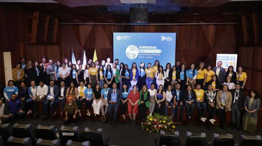 Jóvenes participantes de las Jornadas de Ideación para el Futuro de Honduras junto a mentores de las Agencias, Fondos y Programas de Naciones Unidas en el Auditorio Alma Mater de la Universidad Nacional Autónoma de Honduras, vistiendo camisetas azul cielo y amarillas, representando los colores de la Cumbre del Futuro.